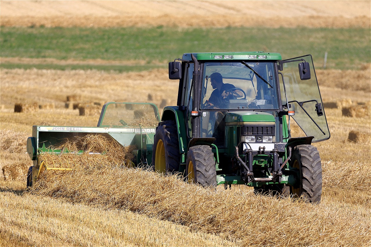 a tractor that is sitting in the grass, by David Simpson, figuration libre, field of hay, photograph credit: ap, file photo, working out in the field