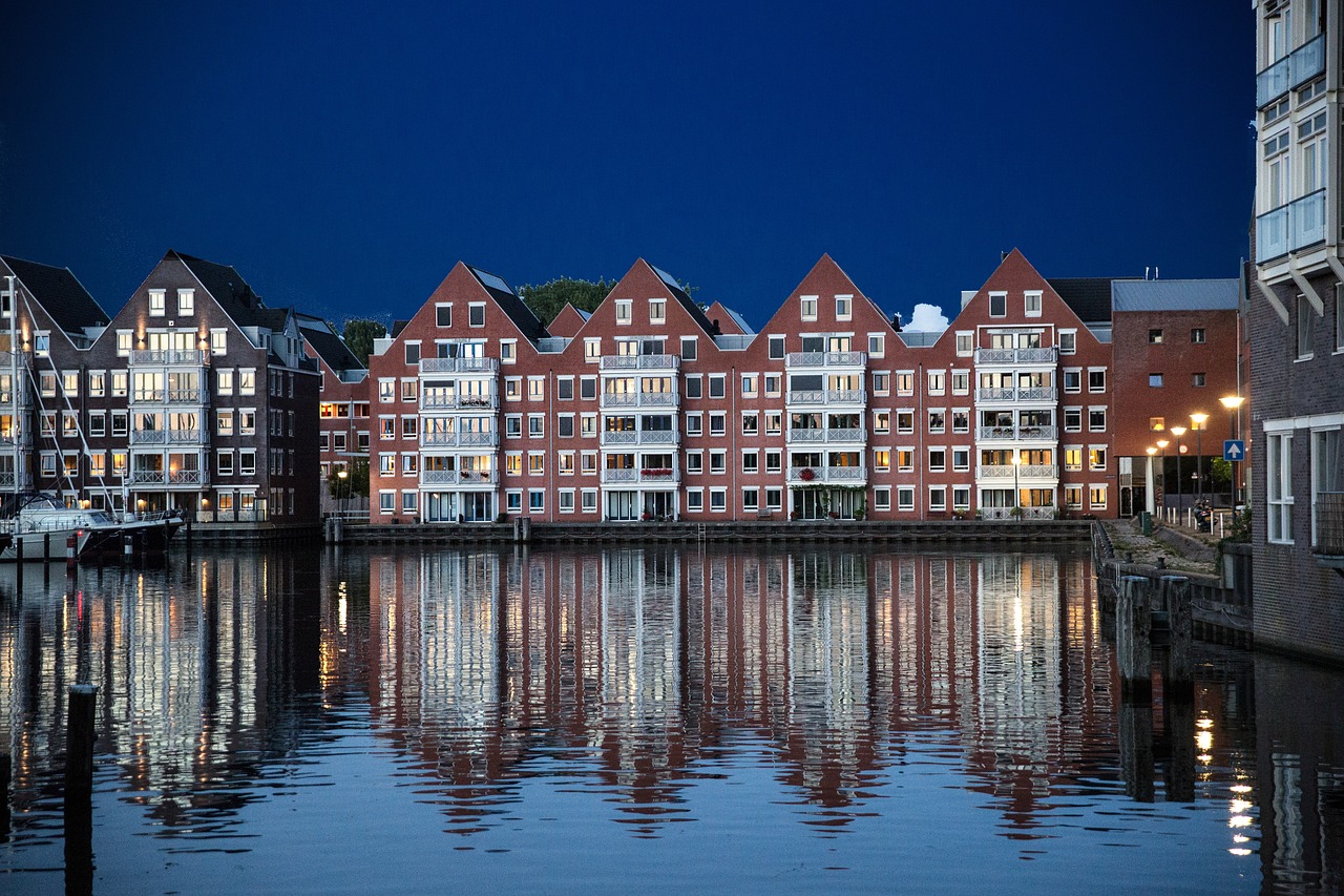 a row of buildings next to a body of water, by Troels Wörsel, shutterstock, summer night, lower saxony, ten flats, new england architecture