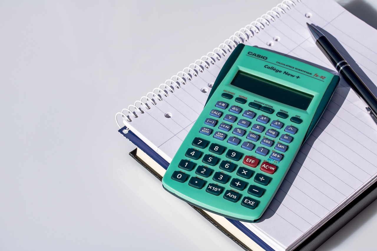 a calculator sitting on top of a notebook next to a pen, a photo, catalog photo, green and blue color scheme, 8 0 mm photo, college
