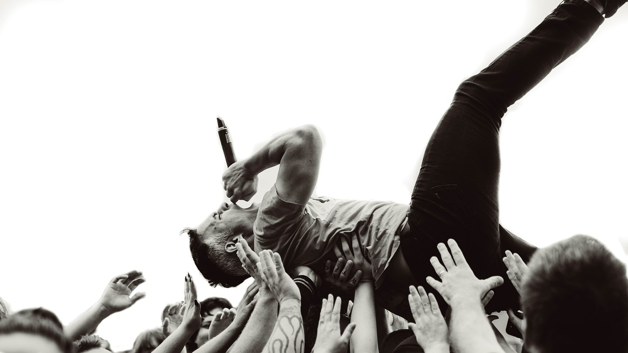 a man falling into the air in front of a crowd of people, a black and white photo, by Matt Cavotta, black lips, perfect detail, trent reznor, extreme realism