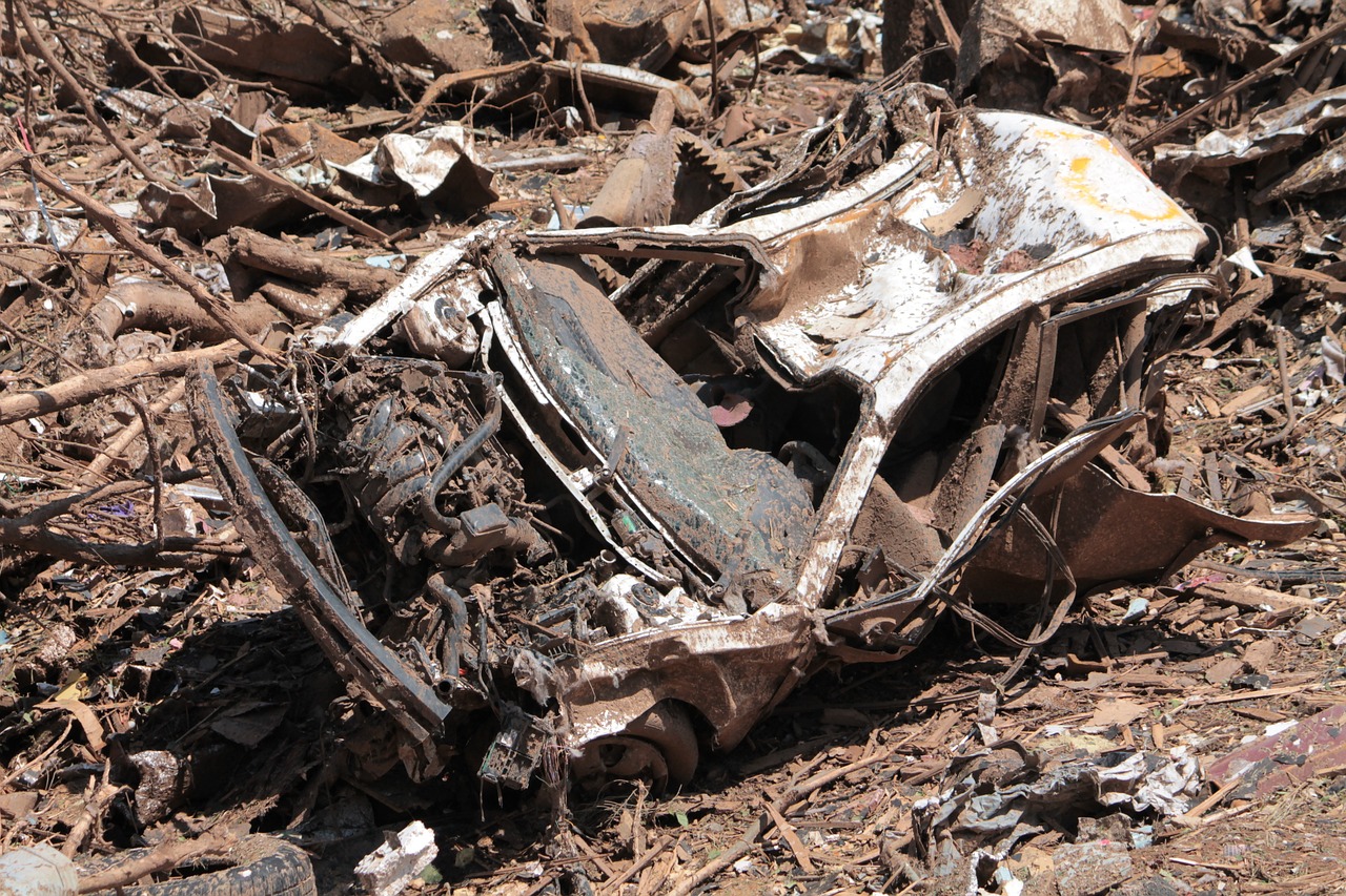 a car sitting on top of a pile of rubble, auto-destructive art, detailed zoom photo, high res photo, mining scrap metal, dead bodies scattered in mud