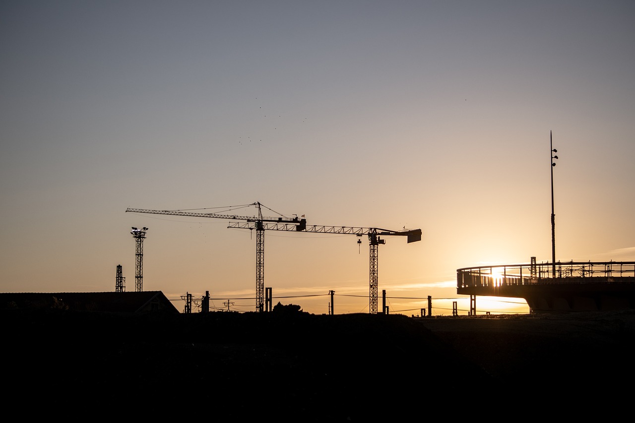 a crane is silhouetted against the setting sun, a photo, by Mathias Kollros, shutterstock, bauhaus, swedish urban landscape, 7 0 mm photo, under construction, stock photo