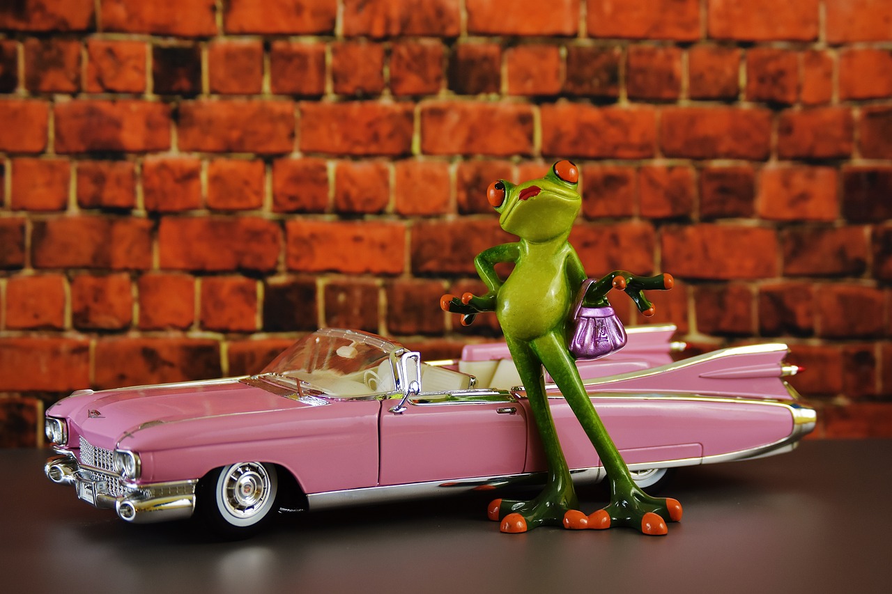 a frog figurine sitting on top of a pink car, by Tom Carapic, pixabay contest winner, retrofuturism, kenner style action figure, 1960s spy, kermit dressed as the undertaker, stock photo