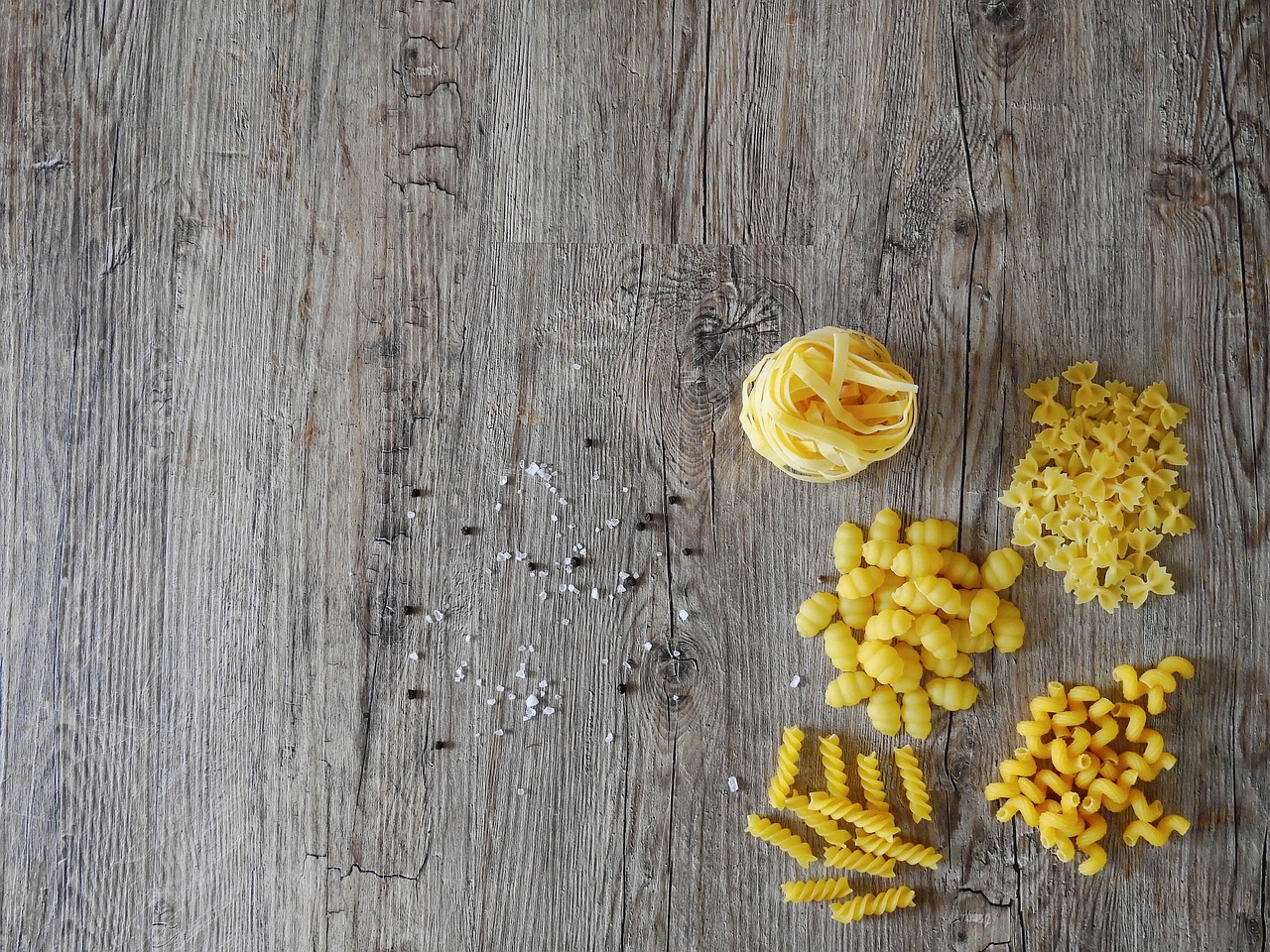 a bunch of pasta sitting on top of a wooden table, a portrait, renaissance, colors: yellow, flatlay, grain”, twinkling and spiral nubela