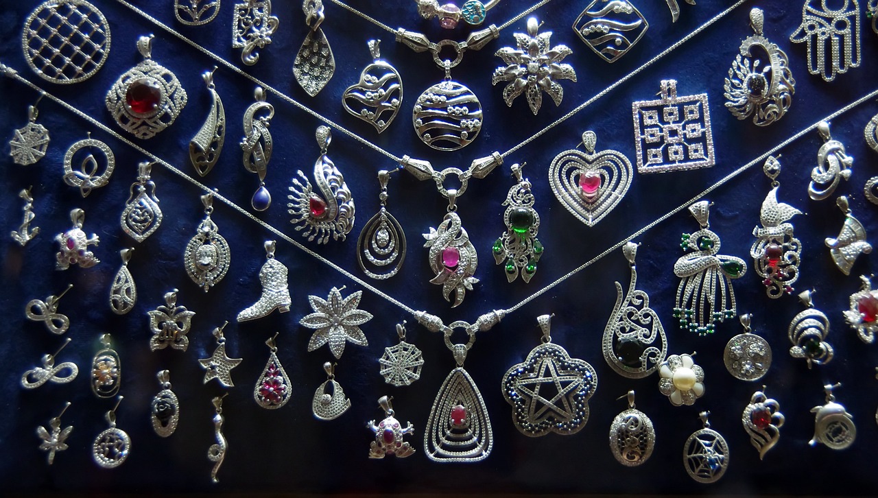 a display case filled with lots of different types of jewelry, by Ramón Silva, flickr, celtic symbols, silver and sapphire, pendants, bangalore