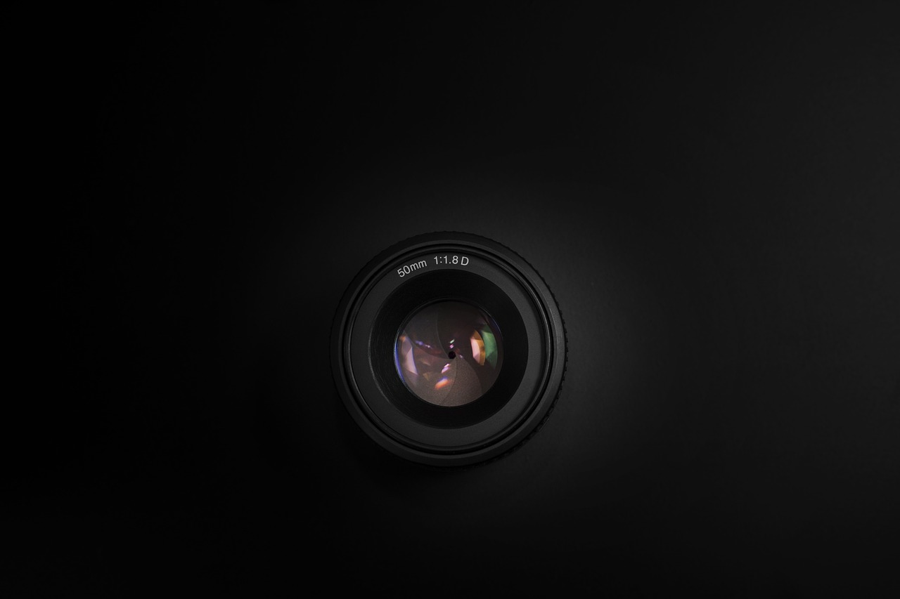 a close up of a camera lens on a black background, by Daniel Seghers, dark wallpaper, a round minimalist behind, sony lens, black studio background color