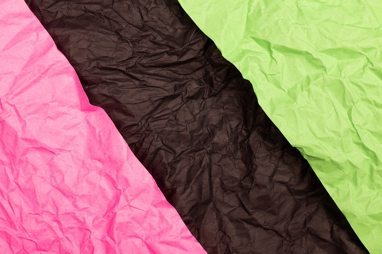a close up of three different colored sheets of paper, a stock photo, by Julian Allen, shutterstock, neon pink and black color scheme, paper crumpled texture, green and black colors, packshot
