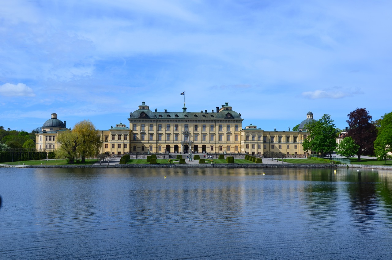 a large building sitting on top of a lake, by Samu Börtsök, shutterstock, neoclassicism, swedish, perfect spring day with, fully body photo, highly detailed photo