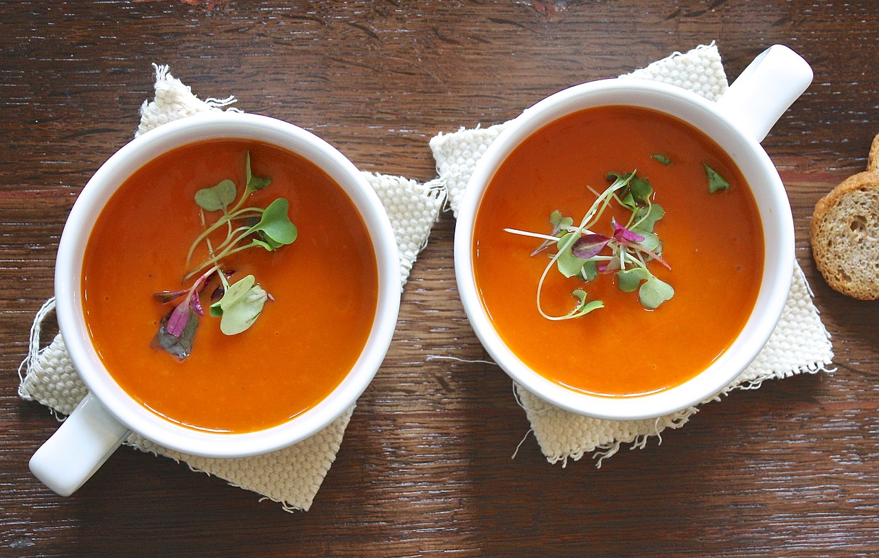 a couple of cups of soup sitting on top of a table, pixabay, tomato sauce, stems, glazed, vibrant but dreary orange