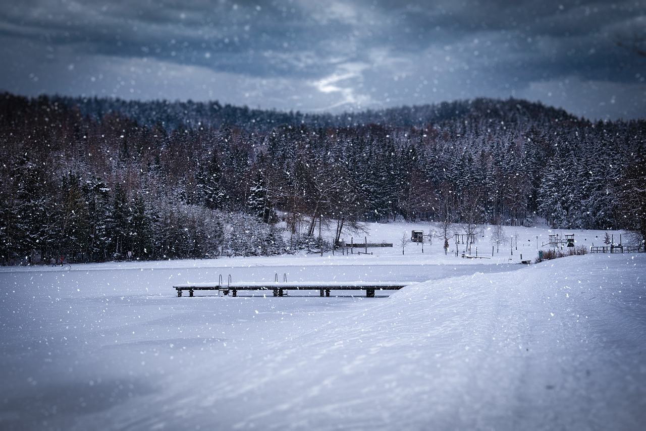 a bench sitting on top of a snow covered field, a tilt shift photo, by Hristofor Žefarović, shutterstock, folk art, lake in the forest, stormy weather at night, stock photo, wooden bridge