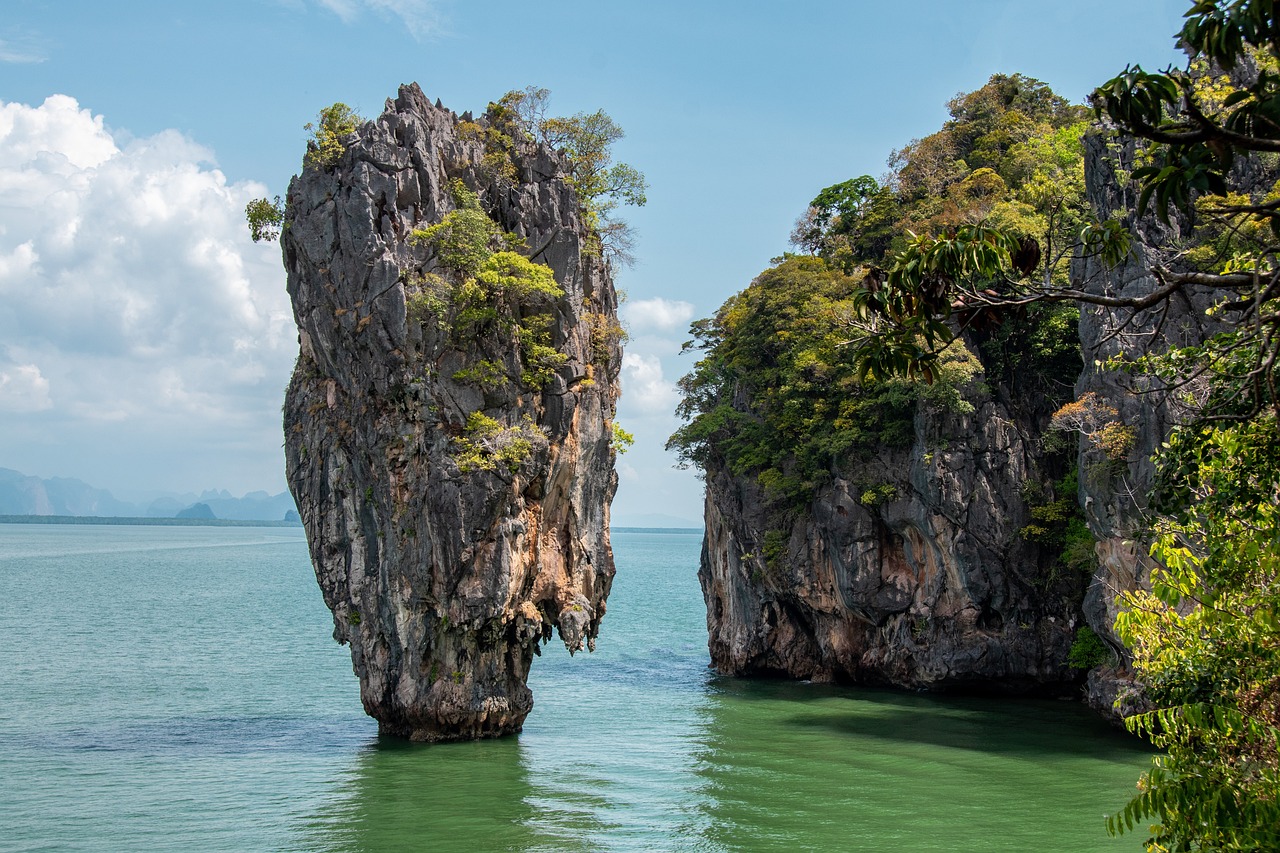 a rock formation in the middle of a body of water, by Richard Carline, shutterstock, thailand, gateway, thin face structure, two medium sized islands