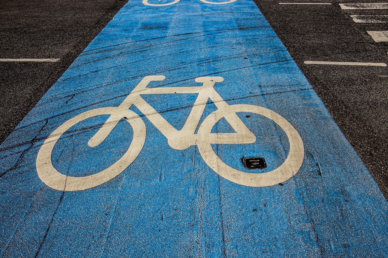 a bike lane with a bicycle painted on it, a stock photo, by Richard Carline, shutterstock, blue colour scheme, symmetrical detail, scotland, big details