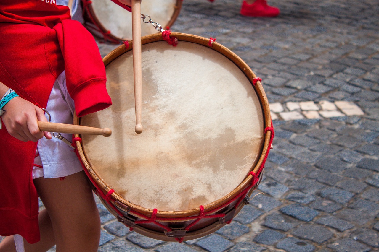 a close up of a person holding a drum, a picture, by Etienne Delessert, shutterstock, nazare (portugal), red uniform, in the middle of the day, usa-sep 20