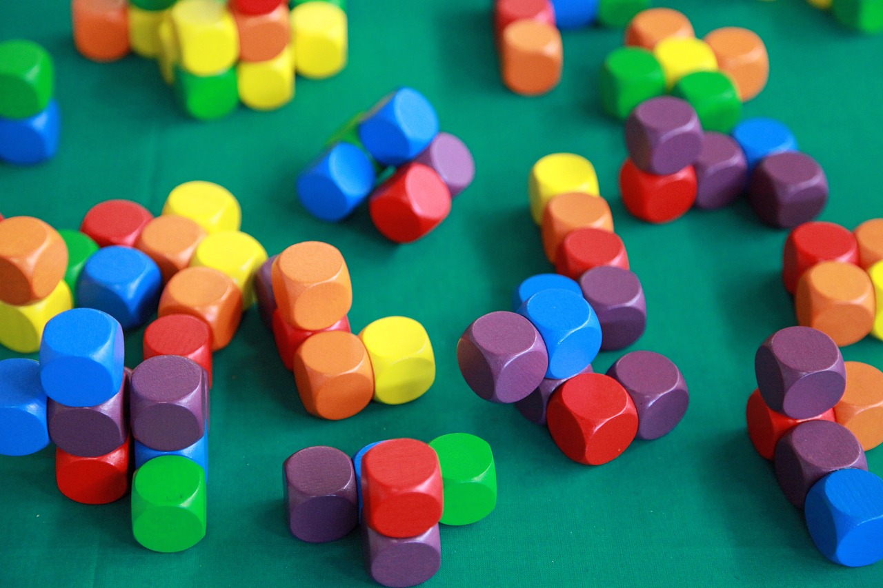 a green table topped with lots of colorful wooden shapes, a picture, flickr, square shapes, dices, closeup photo, block head