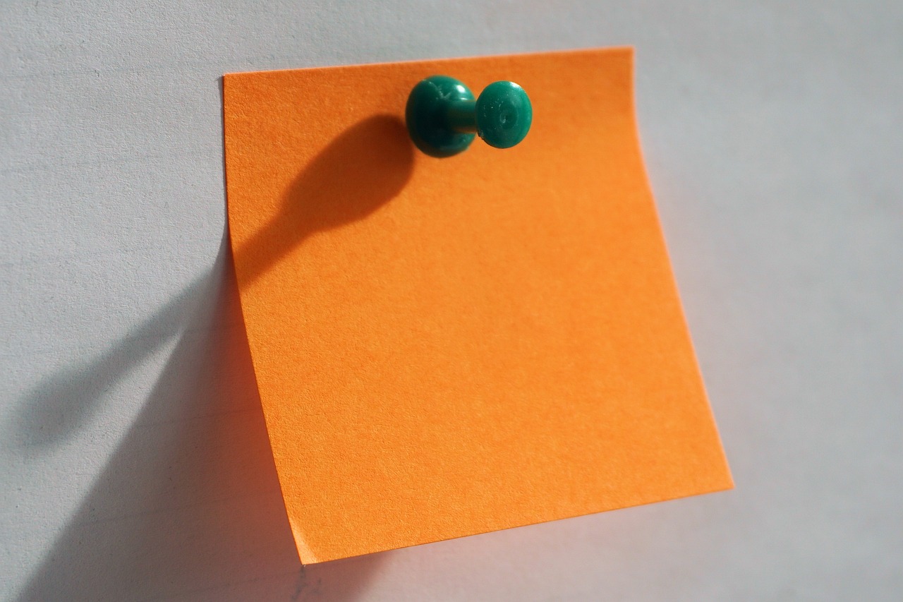 a close up of a post it on a wall, flickr, postminimalism, emerald earrings, orange color, beads of sweat, teal paper