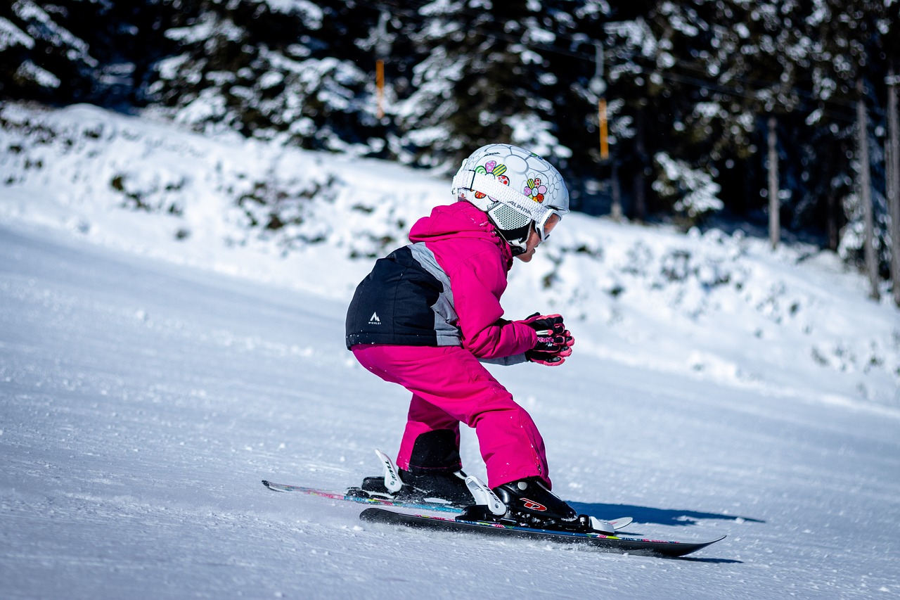 a person riding skis down a snow covered slope, a portrait, flickr, pink girl, little kid, shot on nikon z9, side view of her taking steps
