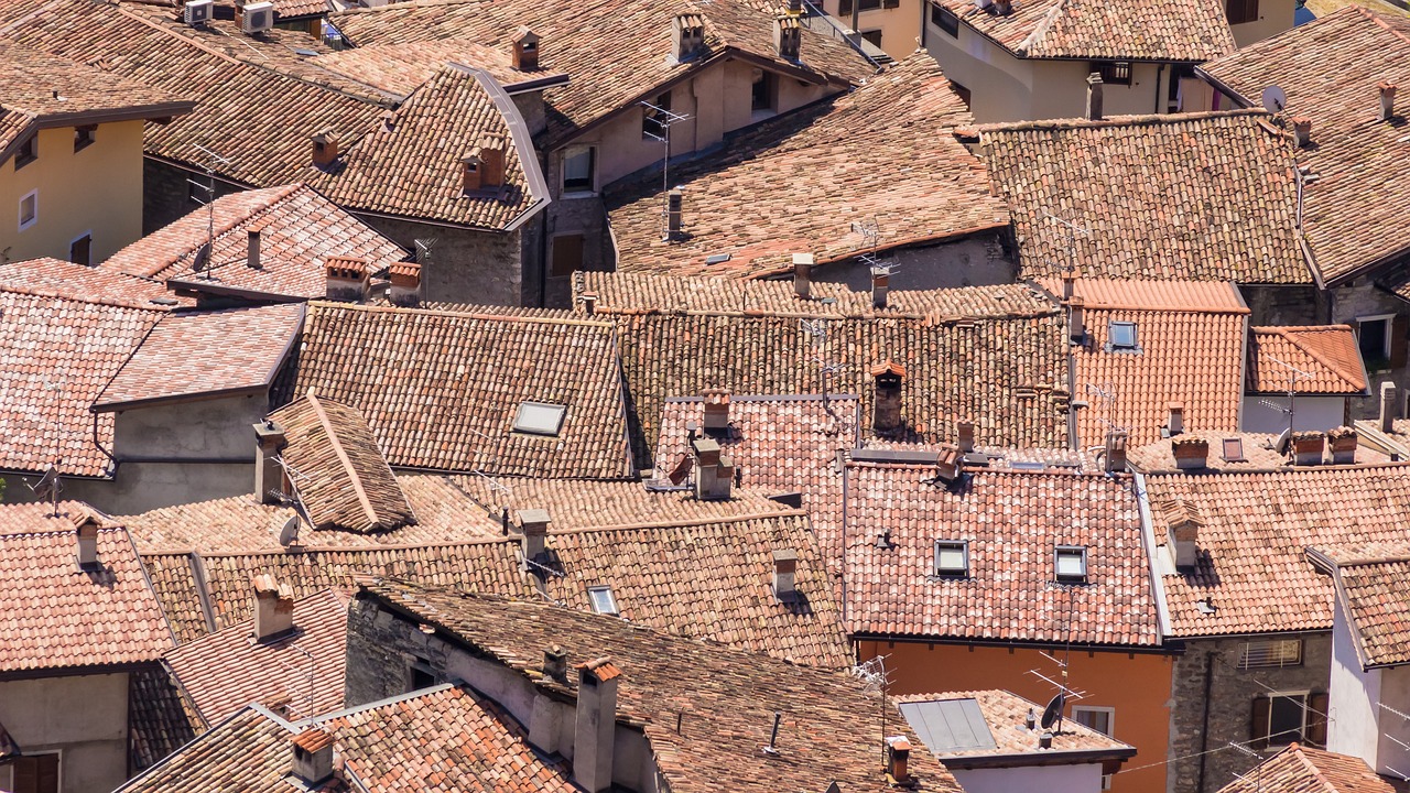 a bird's eye view of a group of rooftops, a mosaic, by Richard Carline, shutterstock, italy, complex layered composition!!, cloicsonne, reddish