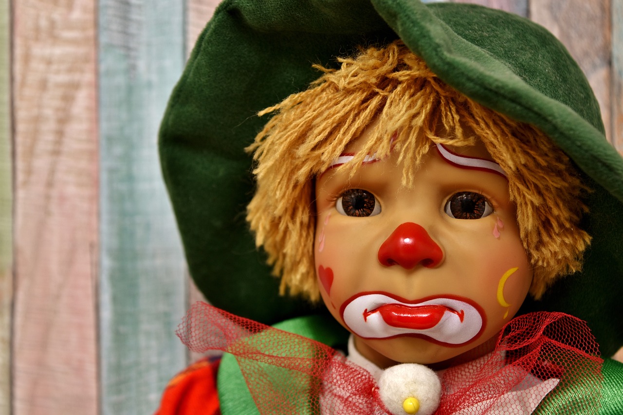 a close up of a clown doll wearing a green hat, trending on pixabay, sqare-jawed in medieval clothing, etc, toddler, super detailed image