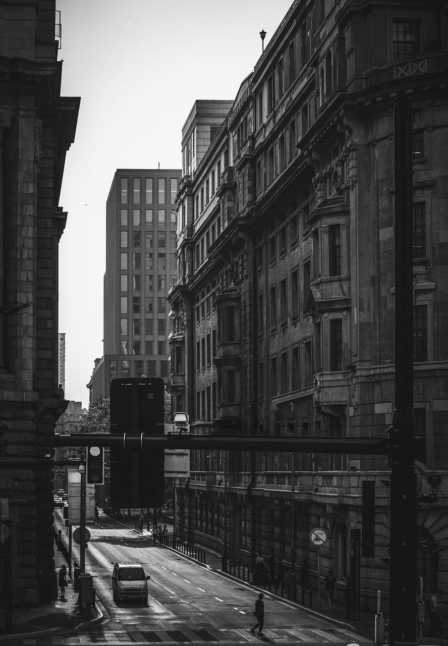 a black and white photo of a city street, by Lee Loughridge, sigma 85/1.2 portrait, tall thin build, manchester, city view
