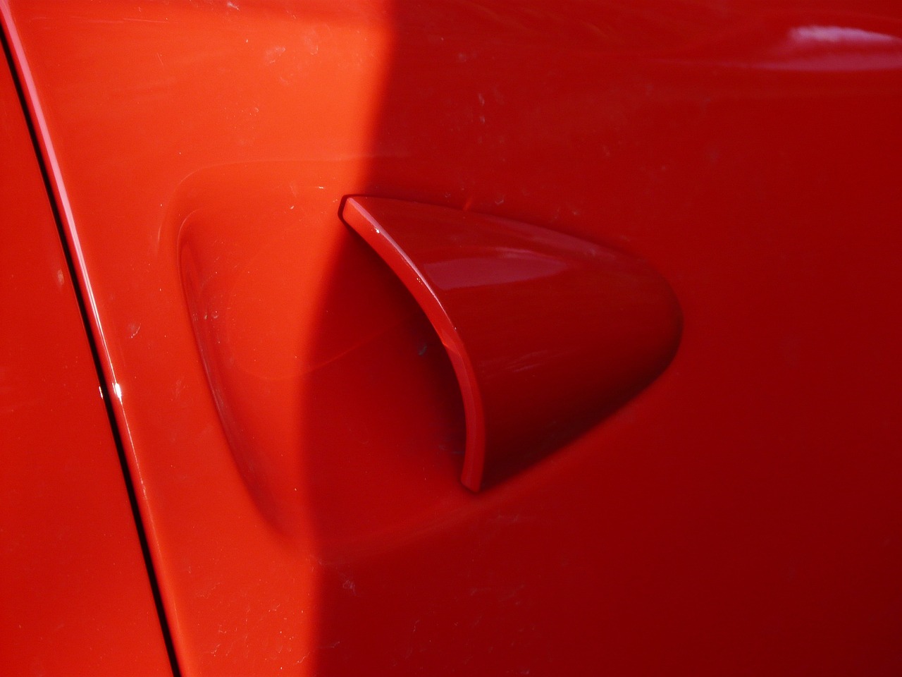 a close up of a red car door handle, by Doug Ohlson, plasticien, respiratory flap, cone shaped, aquiline nose!!, high res