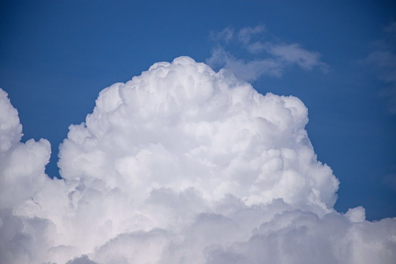 a plane flying through a cloud filled blue sky, a picture, by Jan Rustem, shutterstock, minimalism, giant cumulonimbus cloud, high detailed close up of, stock photo