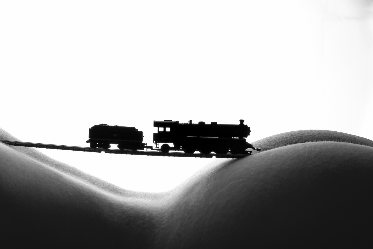 a black and white photo of a toy train, a black and white photo, inspired by Otto Eckmann, figuration libre, sexy :8, big and small, siluette, giantess