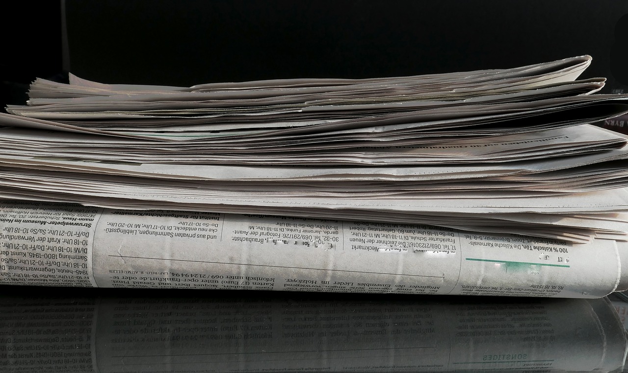 a stack of newspapers sitting on top of a table, by John Murdoch, on black background, gigapixel photo, panorama, bangalore