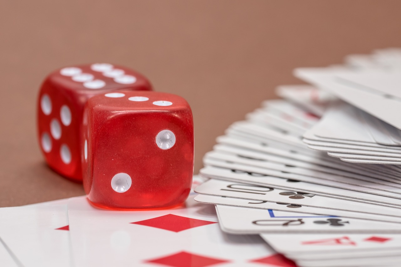 a red dice sitting on top of a pile of playing cards, a picture, shutterstock, dau-al-set, cubes on table, macro detail, fibbonacci, gambles like no one