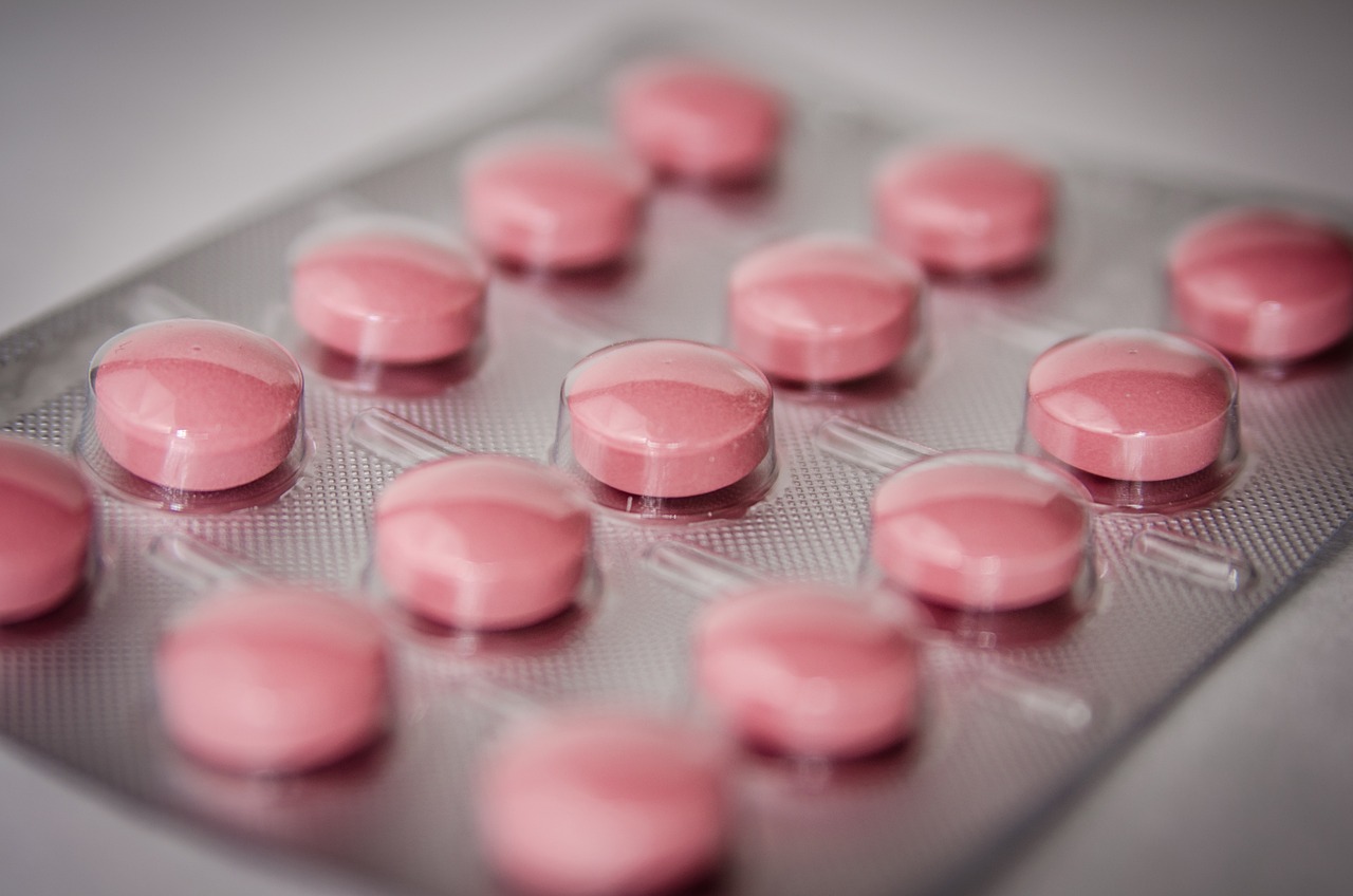 a tray of pink pills sitting on top of a table, antipodeans, packshot, close ups, edge to edge, in plastic