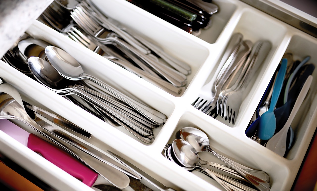 a drawer filled with silverware and utensils, a stock photo, shutterstock, vertical orientation, blurred detail, color picture, high quality product image”