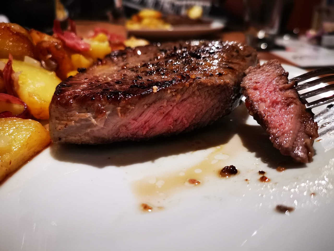 a close up of a plate of food with a fork, a picture, by Tom Wänerstrand, pexels, realism, steak, photo taken with an iphone, side-view, woodfired