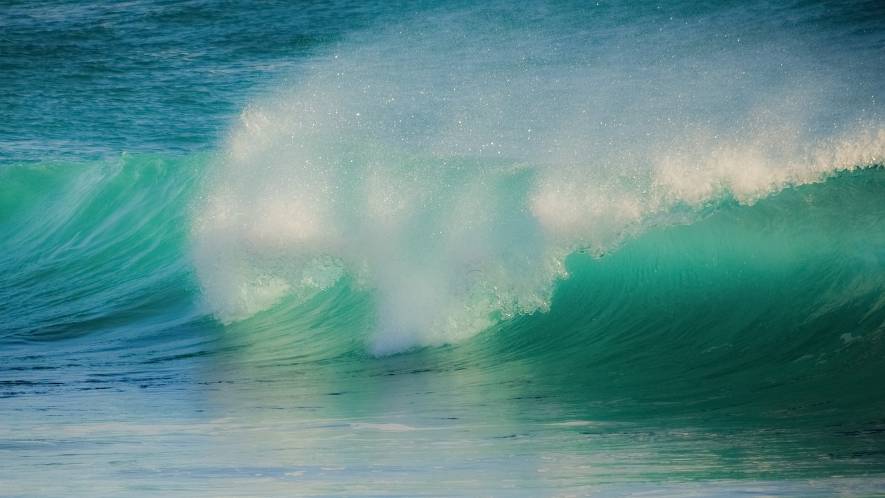 a man riding a wave on top of a surfboard, by Peter Churcher, unsplash, few vivid turquoise highlights, glistening seafoam, abstract photography, soft morning light