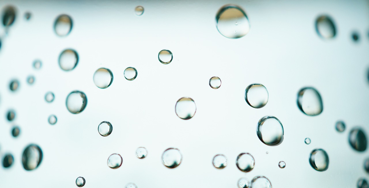 a close up of water droplets on a window, by Jan Rustem, minimalism, floating molecules, lots of bubbles, plain background, bottom - view