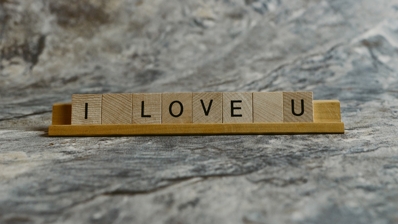 a wooden block with the word i love u written on it, a picture, by Dietmar Damerau, unsplash, animation, stone, composite, love is the most relevant theme