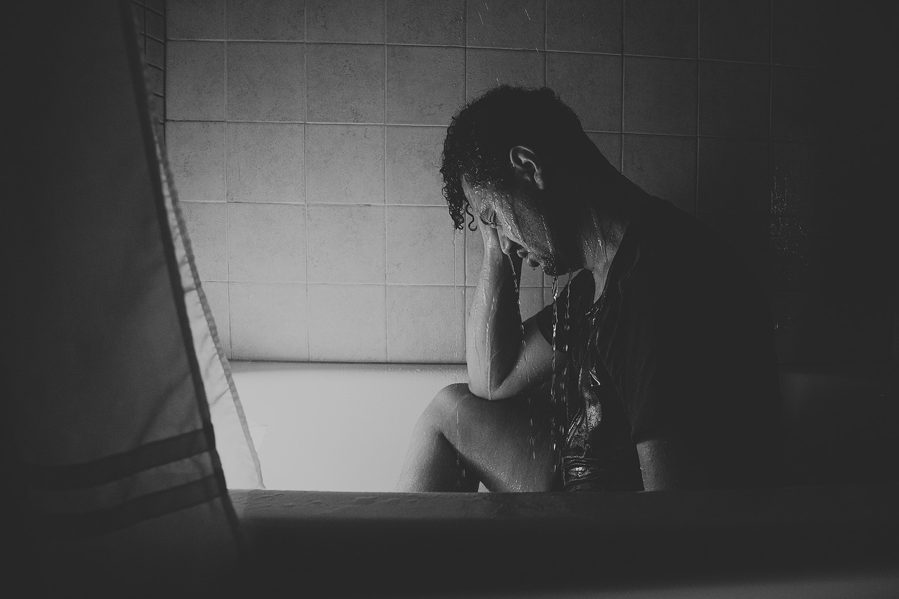 a black and white photo of a man sitting in a bathtub, pexels, people crying, silhouette of man, ptsd, 435456k film