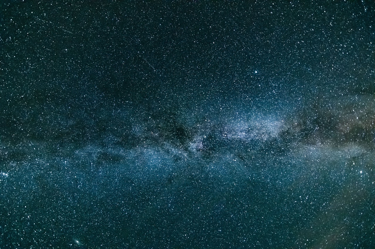 a night sky filled with lots of stars, a microscopic photo, minimalism, the milk way up above, endless cosmos in the background, in the center of the image, wide long shot