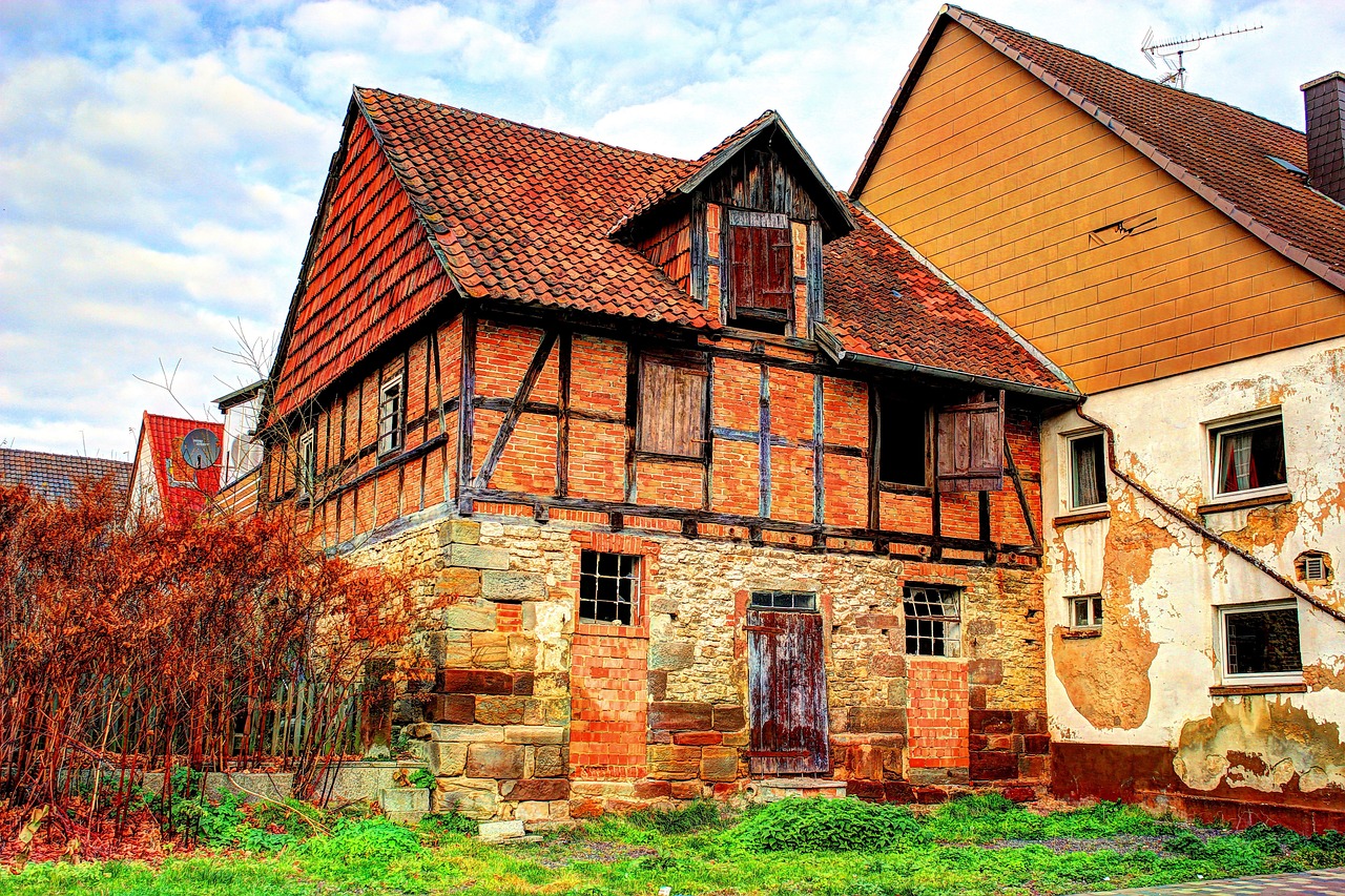 a couple of old buildings sitting next to each other, by Karl Hagedorn, pixabay, renaissance, timbered house with bricks, old lumber mill remains, colorful hd picure, barn
