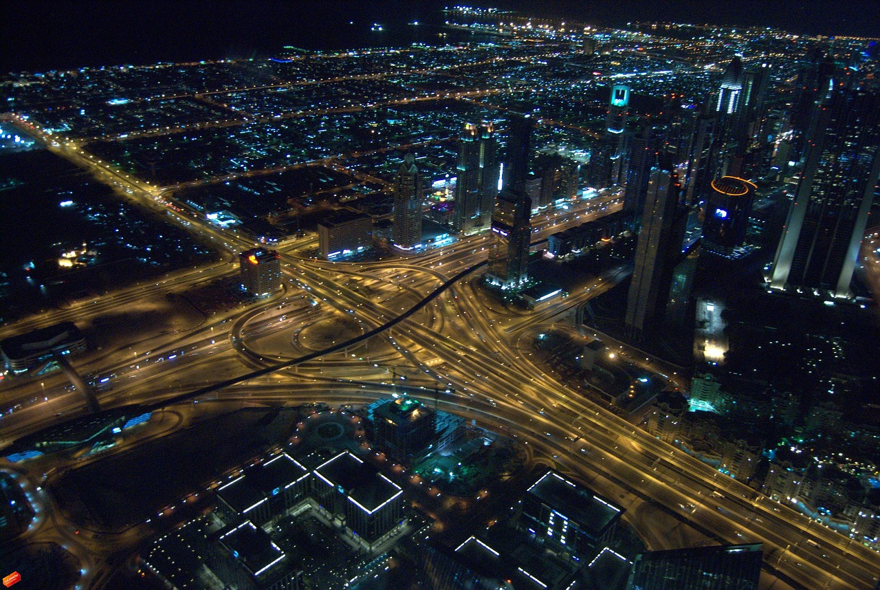 an aerial view of a city at night, flickr, hurufiyya, gta : dubai, intersection, view from the side”