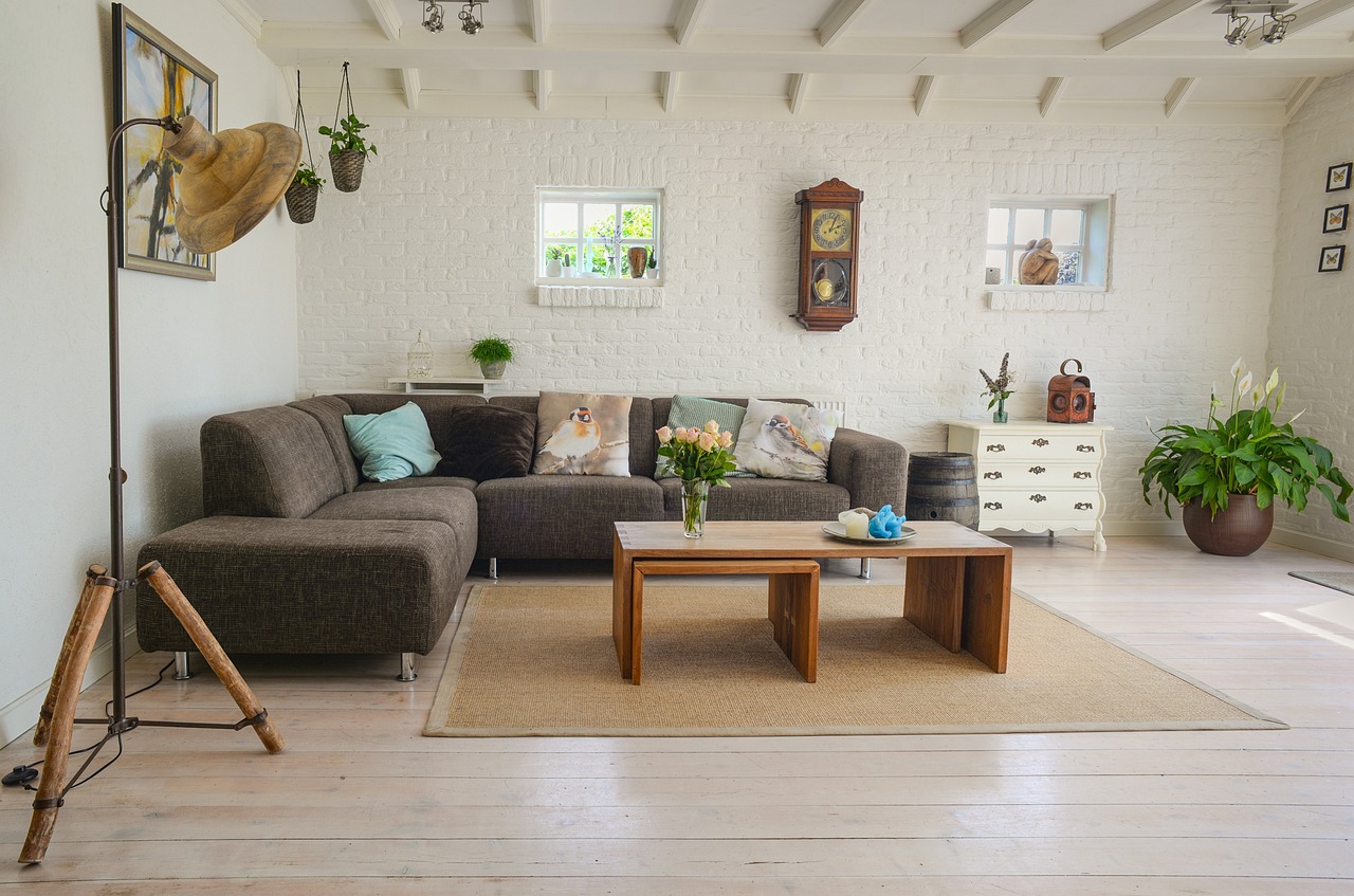 a living room with a couch and a coffee table, inspired by William Home Lizars, pexels, wooden floors, village house, white wall coloured workshop, lavishly decorated