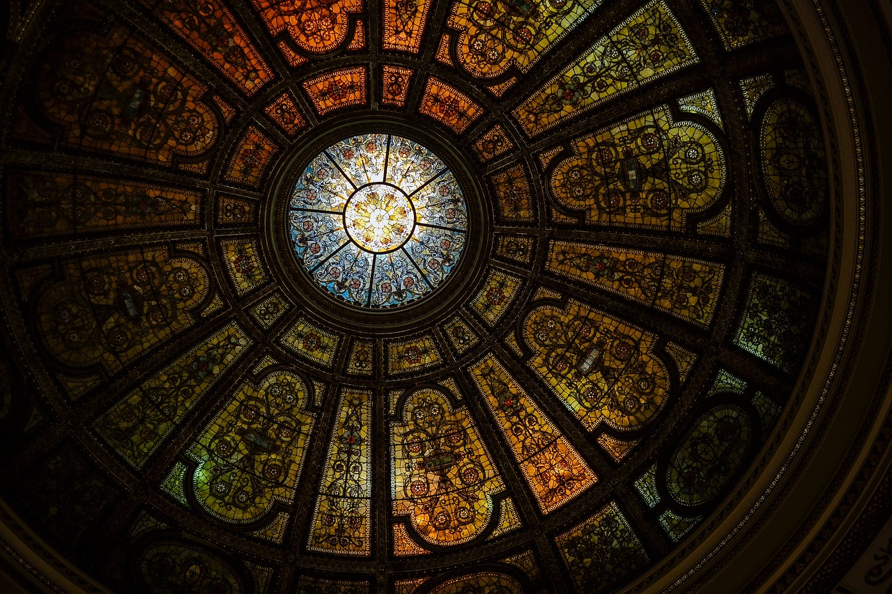 a circular stained glass window in a building, inspired by Louis Comfort Tiffany, unsplash contest winner, intricate detailed roof, chicago, “ golden chalice, photo taken with sony a7r