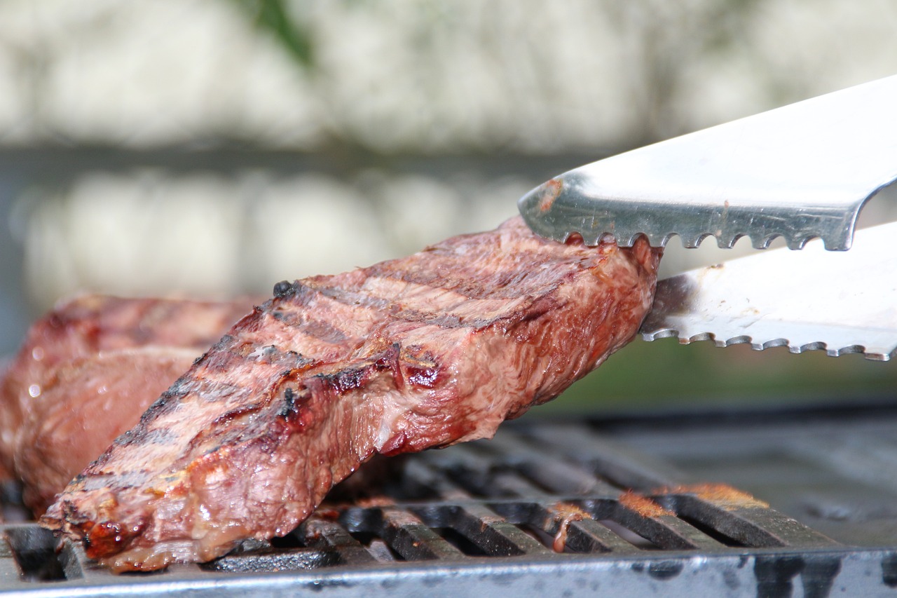 a steak being cooked on a grill with a knife, a picture, figuration libre, closeup photo, detailed zoom photo, wide shot photo