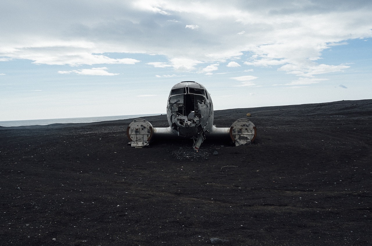an airplane that is sitting in the dirt, a photo, by Andrei Kolkoutine, unsplash, auto-destructive art, sci-fi of iceland landscape, monster ashore, sad face, black sand