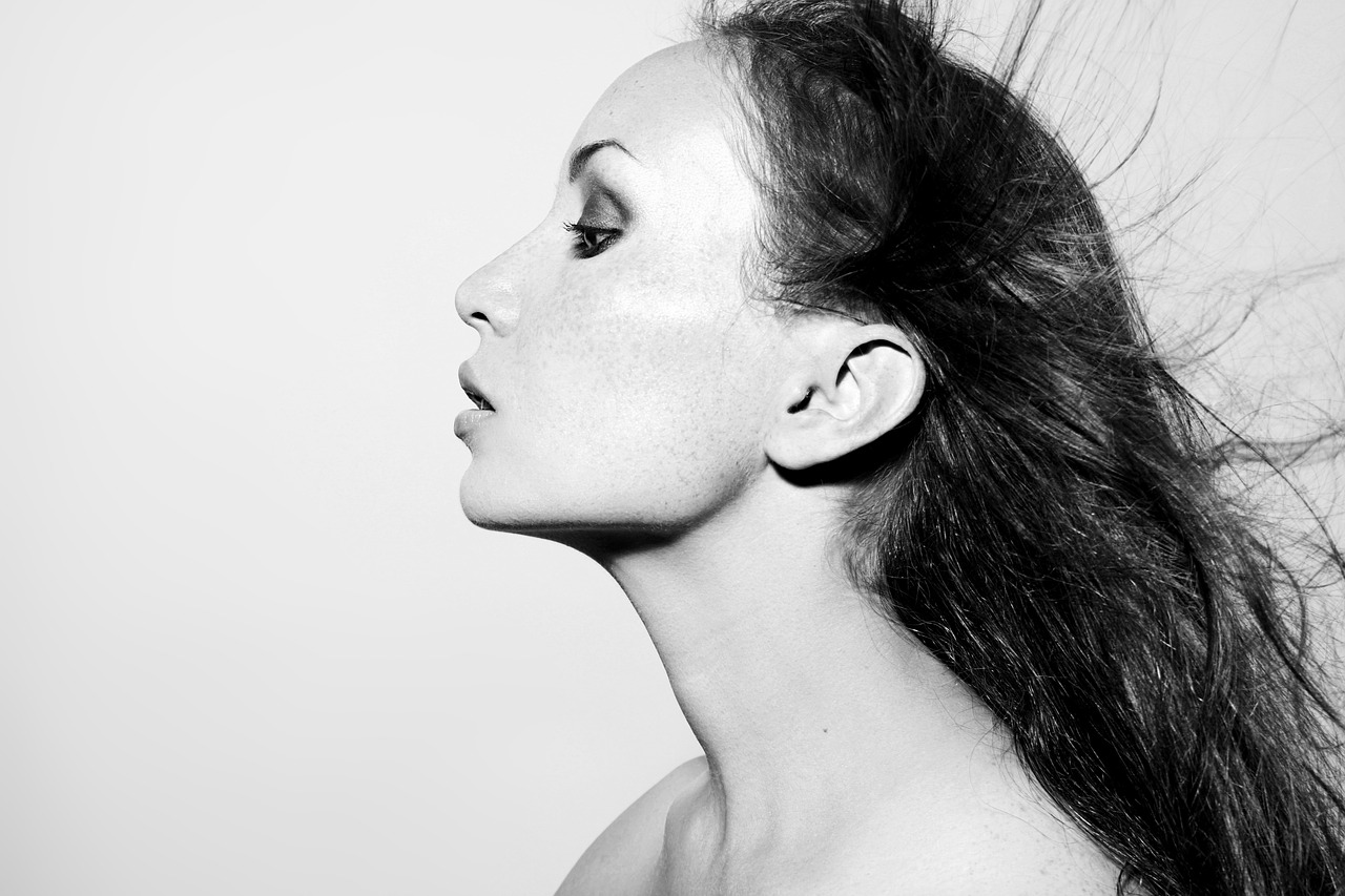 a woman with long hair blowing in the wind, a black and white photo, inspired by Bert Stern, minimalism, bw close - up profile face, portrait of natalie portman, die antwoord yolandi portrait, long neck