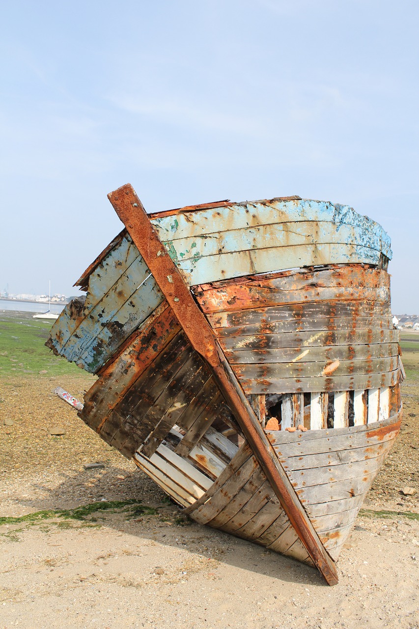 a rusted boat sitting on top of a sandy beach, a photo, renaissance, half body photo, extremely detailed photo, building crumbling, portlet photo