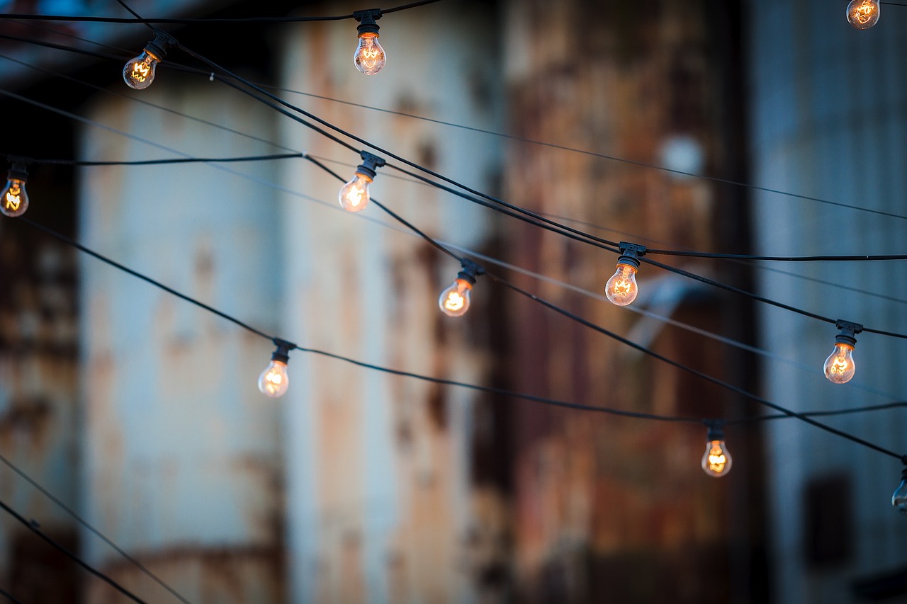 a bunch of light bulbs hanging from a wire, by Lee Loughridge, unsplash, cinematic outdoor lighting, grungy, stock photo, industrial setting