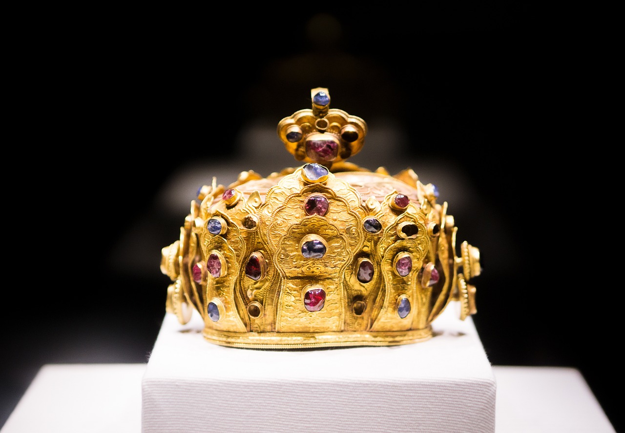 a gold crown sitting on top of a white pedestal, by Jens Søndergaard, flickr, cloisonnism, ornate colored gems, shot on nikon z9, the middle ages, the photo shows a large