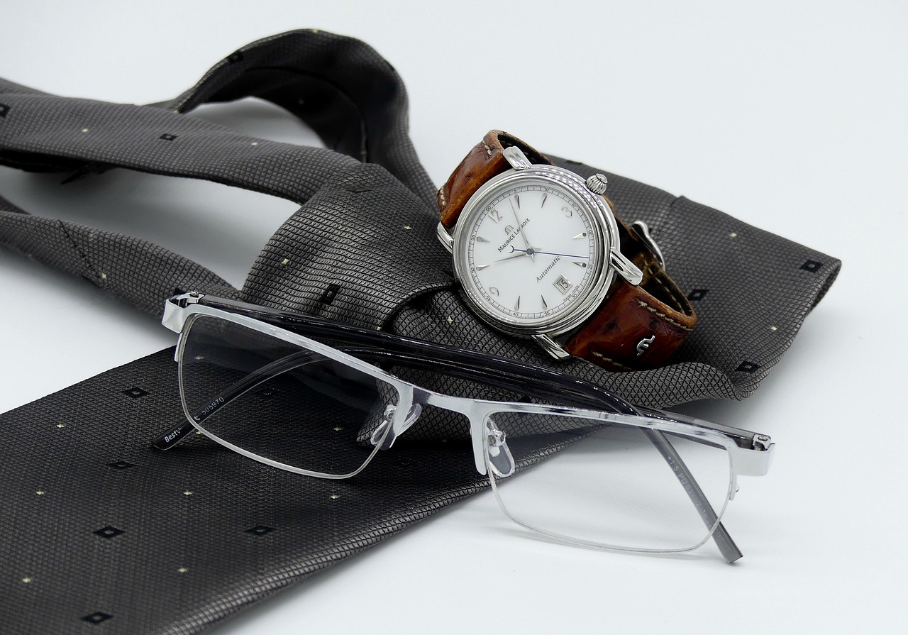 a watch sitting on top of a tie next to a pair of glasses, inspired by Carl Gustaf Pilo, white and silver, detailed product photo, square rimmed glasses, omega