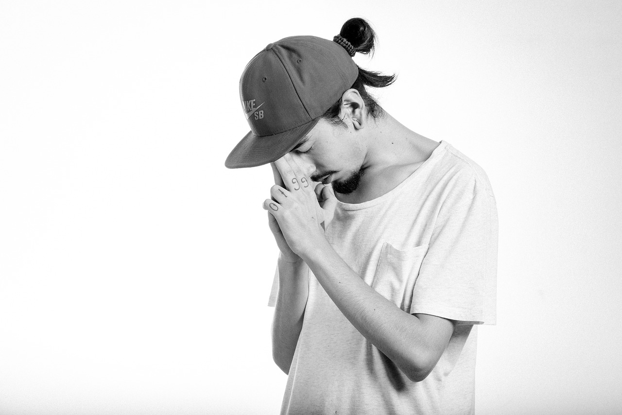 a black and white photo of a man wearing a hat, minimalism, wildstyle, facepalm, portrait of a japanese teen, small chin