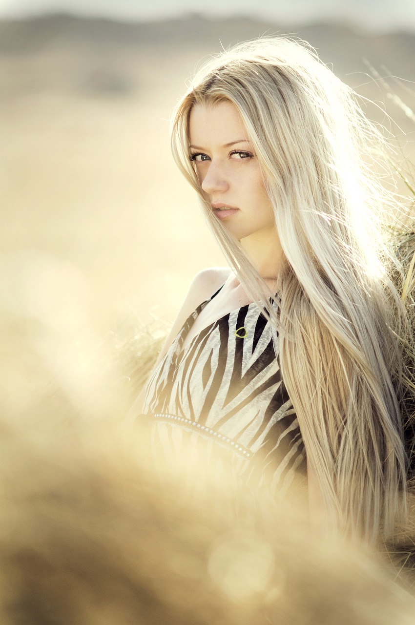 a woman standing next to a horse in a field, by Zofia Stryjenska, tumblr, digital art, light platinum long blond hair, beautiful natural backlight, girl with feathers, her hair is long and straight