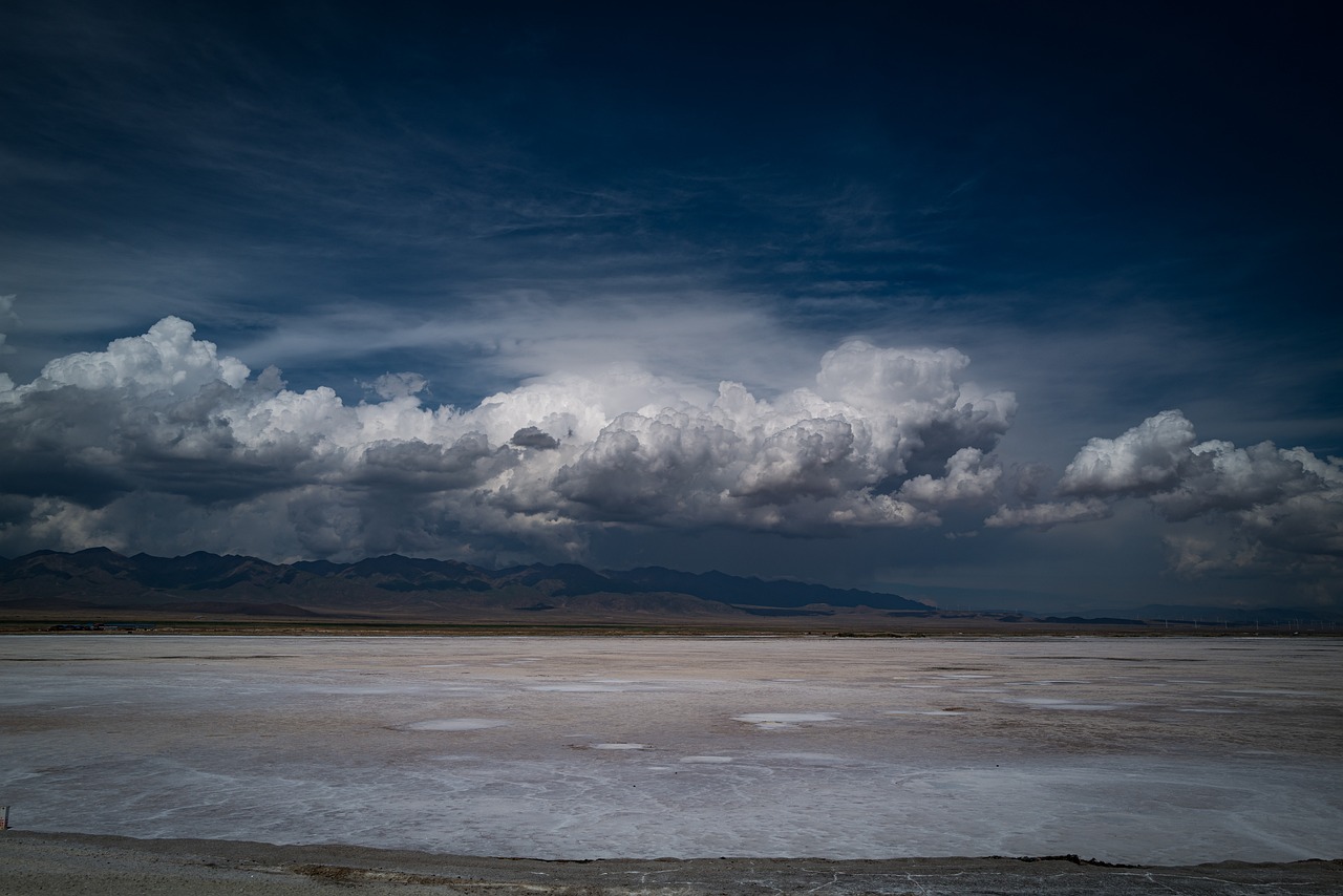 a large body of water sitting under a cloudy sky, a matte painting, unsplash contest winner, death valley, during a hail storm, wide shot!!!!!!, cotton clouds